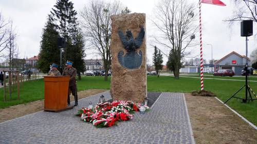 Pomnik będący pamiątką ofiar Zbrodni Katyńskiej z kwiatami.